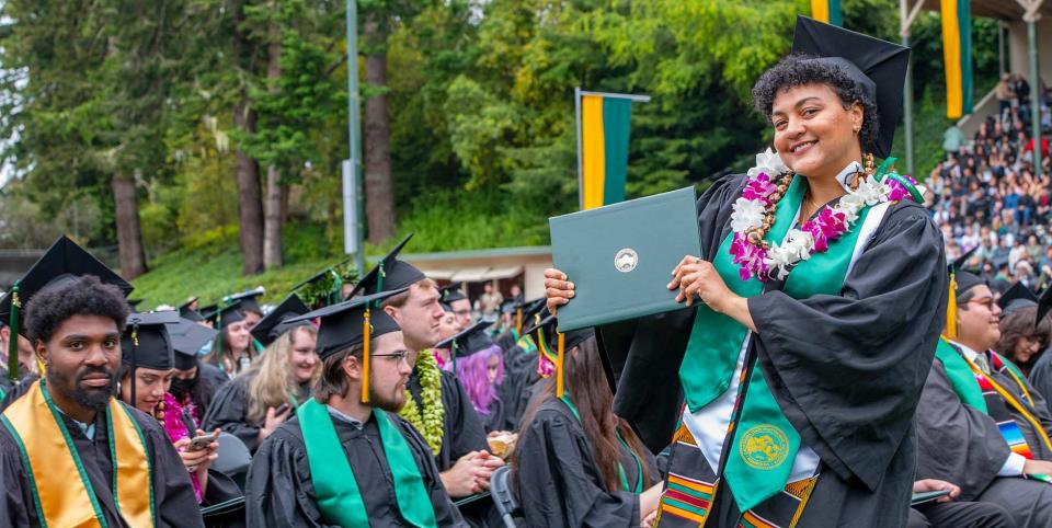 Graduate holding diploma at commencement