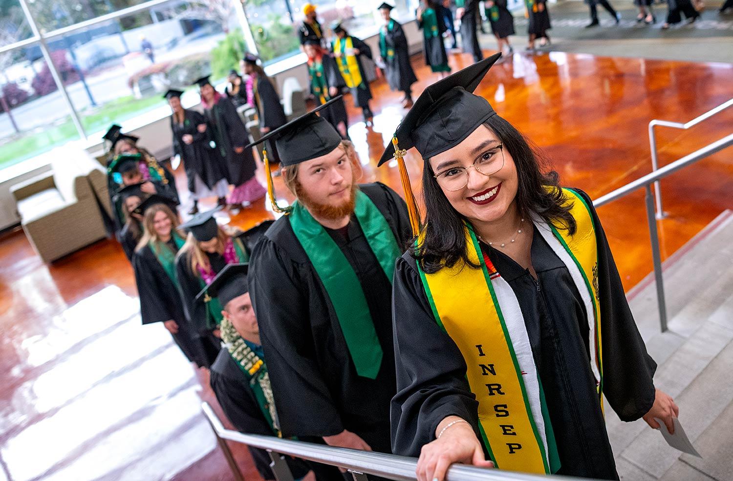 Graduates climbing stairs to Lumberjack Arena